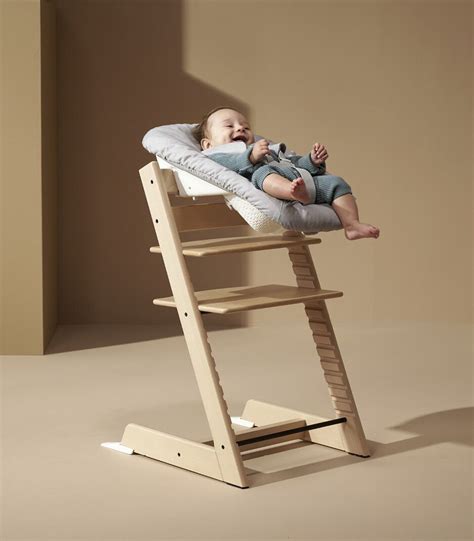 immagine stilizzata del seggiolone Tripp Trapp con Newborn Set montato in un ambiente domestico accogliente