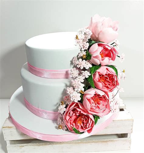 Torta scenografica con diversi livelli e decorazioni floreali in pasta di zucchero