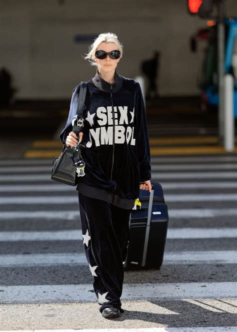 Influencer che indossa una tuta glamour in una strada cittadina