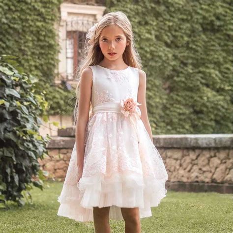 Una bambina che indossa un abito raffinato in un giardino fiorito, rappresentando l'estetica di Miss Grant.