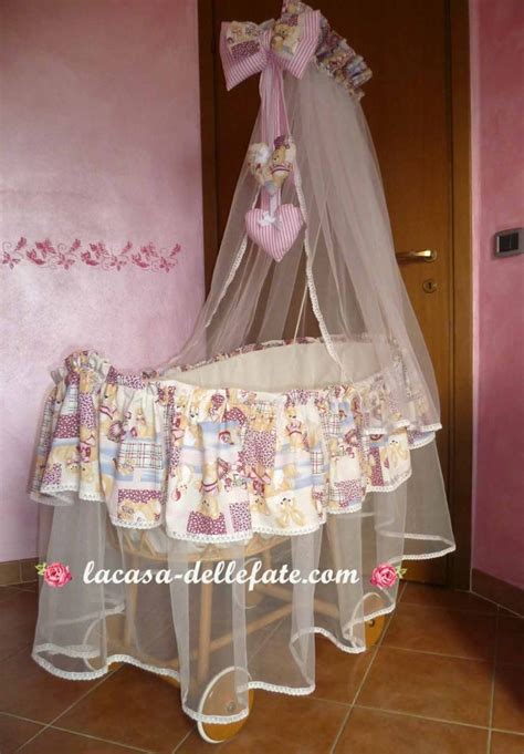 culla con biancheria ricamata e peluche