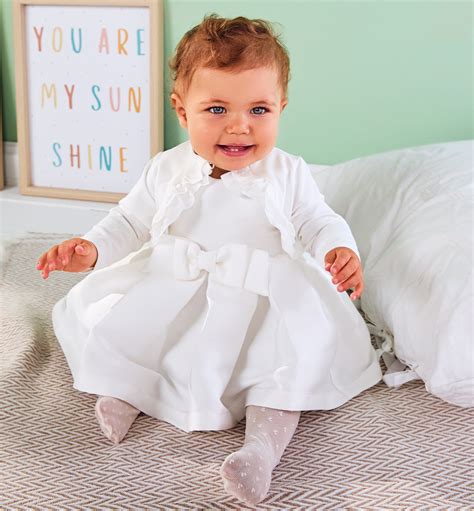 bambina in abito da battesimo bianco