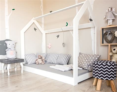 illustrazione di una cameretta montessoriana con un letto a forma di casetta e spazi aperti