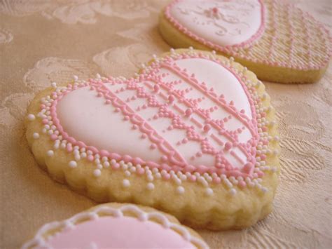 Biscotti a forma di biberon appena decorati con ghiaccia rosa e bianca