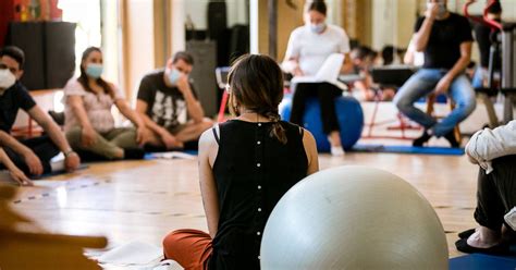 Un gruppo di coppie che partecipa a un incontro di accompagnamento alla nascita con un'ostetrica