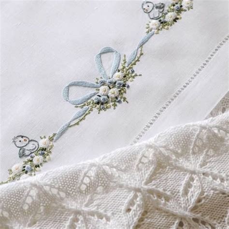 dettagli ricamati su abiti da battesimo