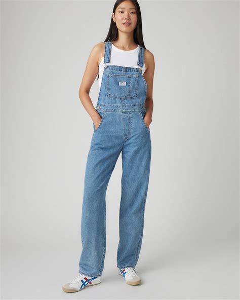 bimba in salopette Levi's che gioca all'aperto