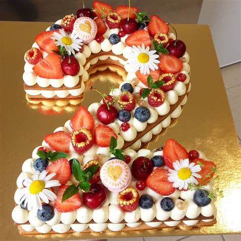 Torta a forma di numero 2 decorata con fiori e macaron