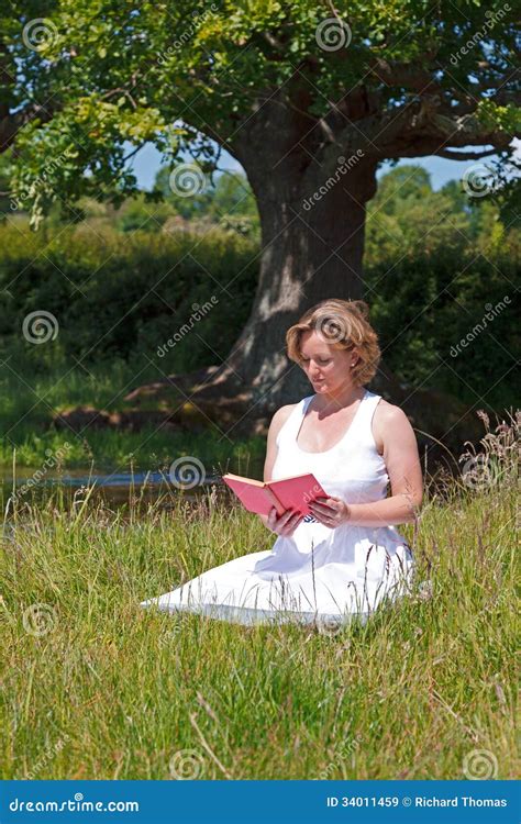 Persona che legge un libro seduta in un prato, con una mente aperta e serena