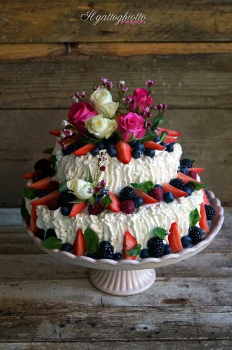 Torta decorata con frutti di bosco freschi e fiori edibili