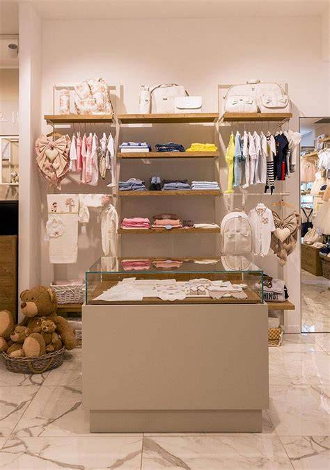 Una vetrina di un negozio di abbigliamento per bambini ben curata con esposizione stagionale