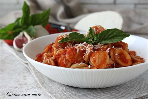 Un piatto di orecchiette con pomodoro e basilico