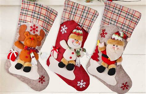 bambini seduti a un tavolo che colorano calze della Befana stampate su carta con matite colorate