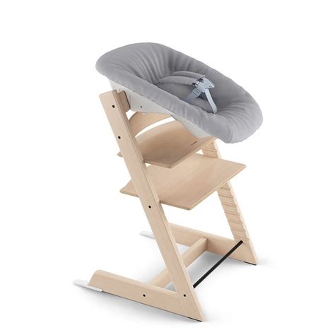 Bambino con imbracatura di sicurezza a cinque punti nella sdraietta Stokke Steps