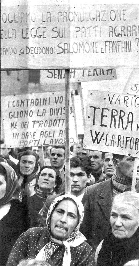 Manifestazione contadina in Sicilia nel dopoguerra con bandiere e cartelli per la riforma agraria