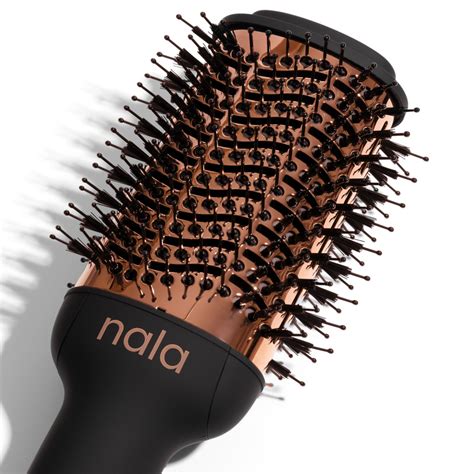 donna che utilizza una spazzola volumizzante per sollevare le radici