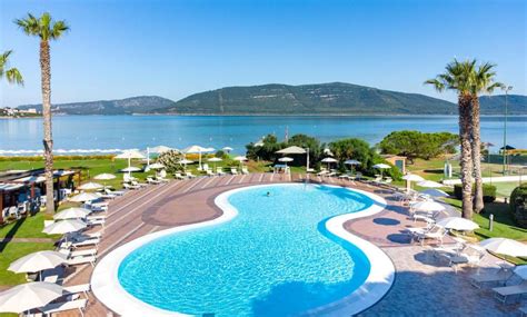 Spiaggia privata di un villaggio sul mare con ombrelloni e bambini che giocano