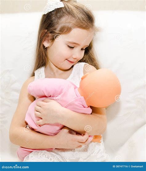 Bambina che gioca con una culla per bambole in legno