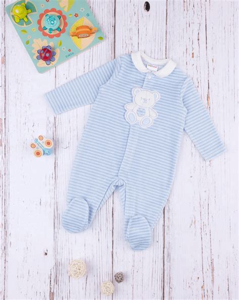 Un set di tutine per neonato in cotone felpato piegate ordinatamente su una superficie morbida