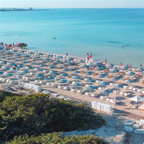 Vista aerea di una spiaggia di Porto Cesareo con ombrelloni e mare azzurro