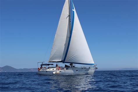 una barca a vela in mare aperto con vele azzurre