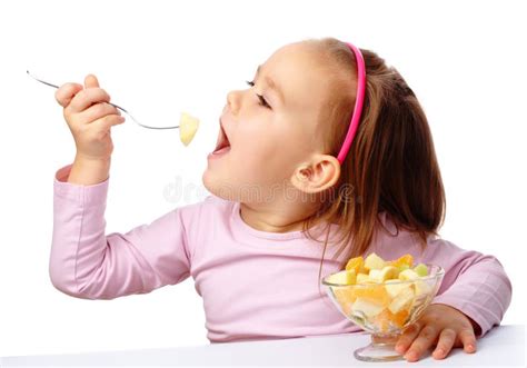 Bambina che mangia una ciotola di mirtilli
