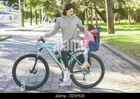 Child on a bike seat enjoying the view with parent