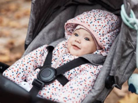 Bambino seduto in un passeggino con una fodera colorata Hauck