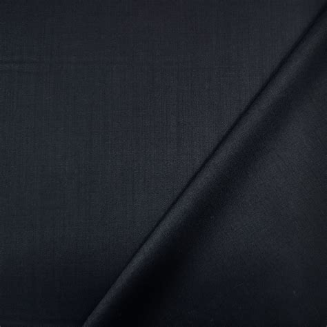 Dettaglio di una sciarpa in maglia di lana blu scuro con finiture Web indossata su un cappottino invernale