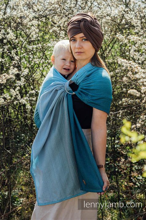 genitore che utilizza una fascia ring sling in un parco