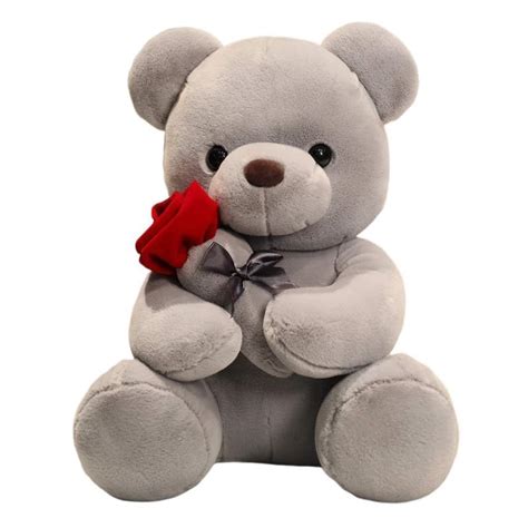 Un orsetto di peluche di alta qualità che indossa un piccolo bavaglino in lino bianco ricamato a mano con motivi floreali e il nome del bambino.