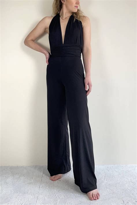 Modella che indossa una tuta jumpsuit nera elegante in un contesto estivo urbano