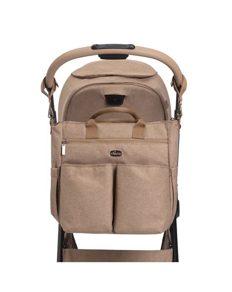 Genitore sorridente trasporta Chicco We nella borsa a tracolla