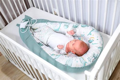 neonato che dorme serenamente in un riduttore per lettino dal design ergonomico
