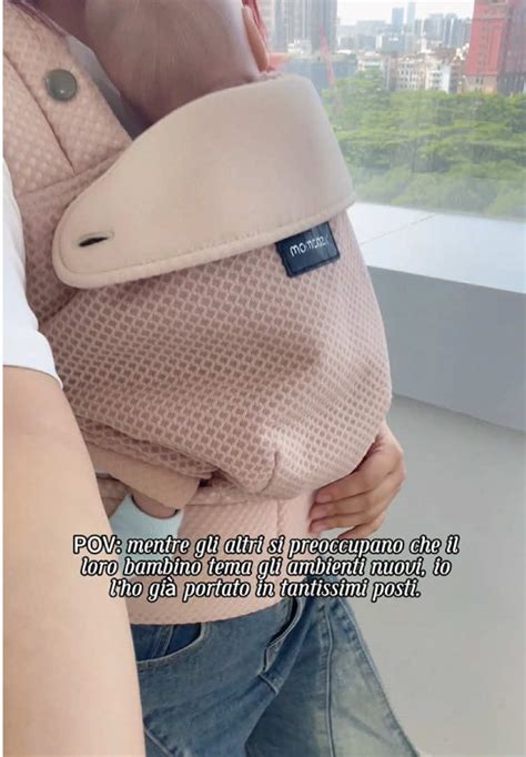 Mamma che indossa un marsupio ergonomico sorridente in un ambiente domestico accogliente