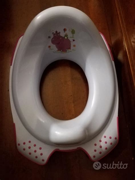bambino che utilizza un riduttore WC in bagno