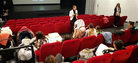 Mamma con neonato al cinema in sala con luci soffuse