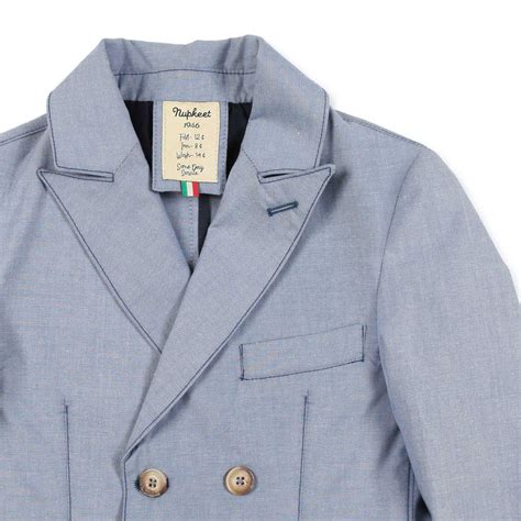 Bambino con giacca doppiopetto in un contesto informale ma elegante