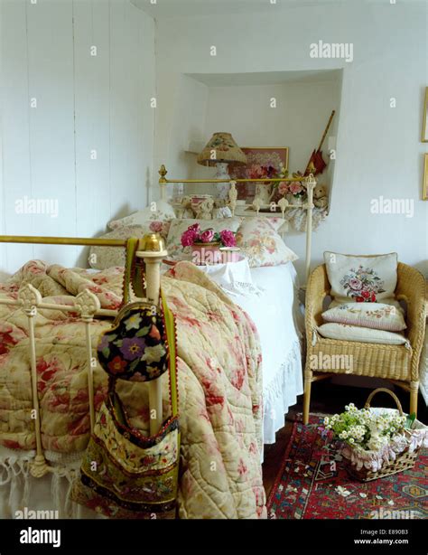 Dettaglio di cuscini in tartan e tende floreali in una camera da letto per bambina