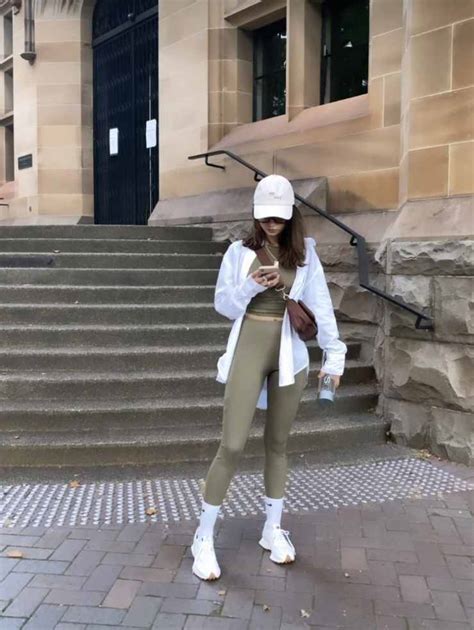 Modella che indossa un outfit sportivo ecosostenibile in un contesto urbano moderno