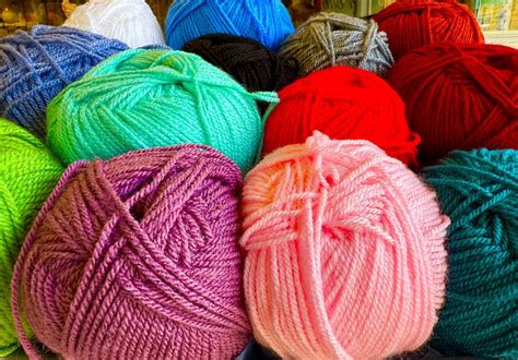 gomitoli di lana colorati disposti in ordine cromatico