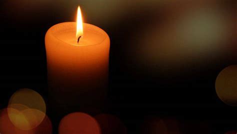 dettaglio ravvicinato di una candela accesa che illumina il buio, simbolo di speranza costante