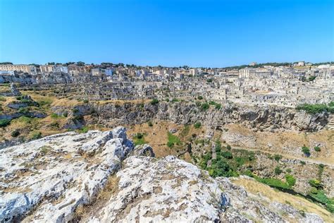 Veduta panoramica dei Sassi di Matera al tramonto, con le rocce che riflettono la luce calda del sole.