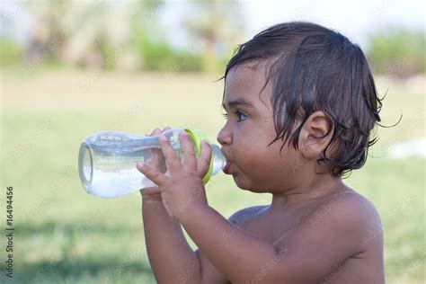 Bambino che beve dal biberon con un sottofondo di acqua fresca
