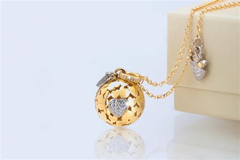 Dettaglio ravvicinato di vari modelli di chiama angeli, dall'argento classico alle versioni placcate oro rosa con decorazioni a cuore.