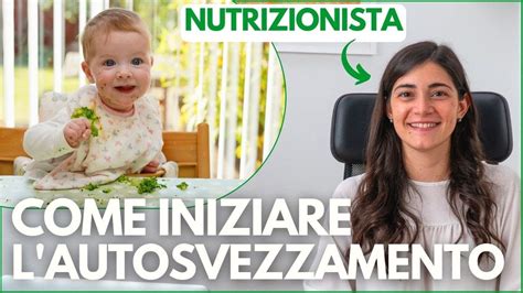 bambino di sette mesi che afferra un fusillo a tavola