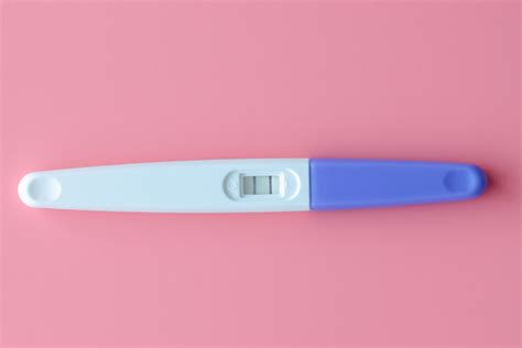 Donna che osserva con attenzione un test di gravidanza domestico in un ambiente casalingo sereno