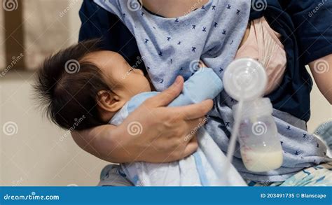 Un neonato prematuro che si nutre di latte materno