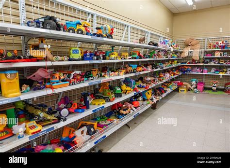 Internal view of a clean, well-organized second-hand children's store with clothes, toys, and small furniture