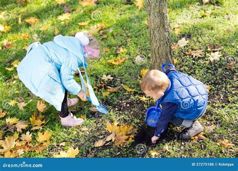 Bambini che raccolgono foglie in un parco